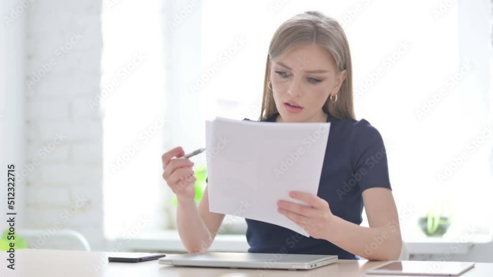 Woman Celebrating Success while Reading Documents in Office Woman Celebrating Success while Reading Documents in Office
