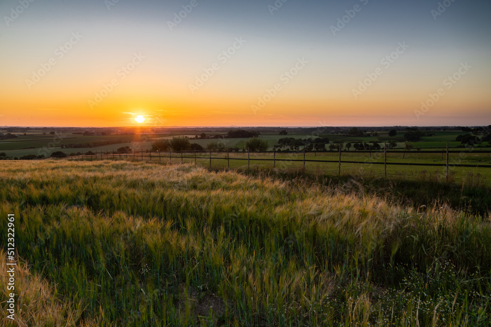 A golden sunset over the rolling hills in Banholt, south Limburg in the Netherlands creating holiday vibes. The views and the warm glow over the landscape create a feeling of being in the Mediterranea