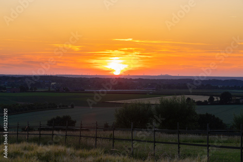 A golden sunset over the rolling hills in Banholt, south Limburg in the Netherlands creating holiday vibes. The views and the warm glow over the landscape create a feeling of being in the Mediterranea photo