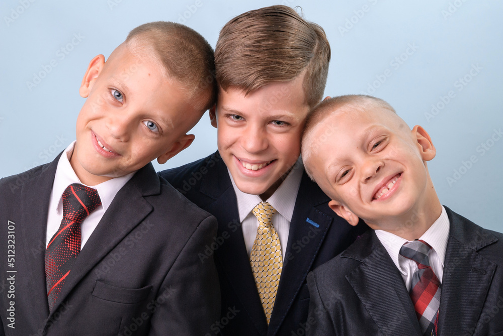 Portrait of three smilig brothers in school, black suits Portrait of three smilig brothers in school, black suits
