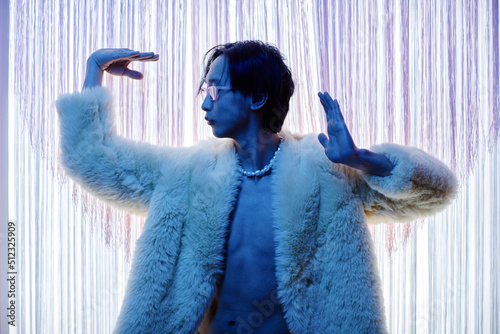 Papier peint Backlit silhouette of extravagant Asian man dancing vogue at party in blue neon