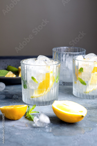 citrus lemonade with mint and lemon in the glass with ice cubes.