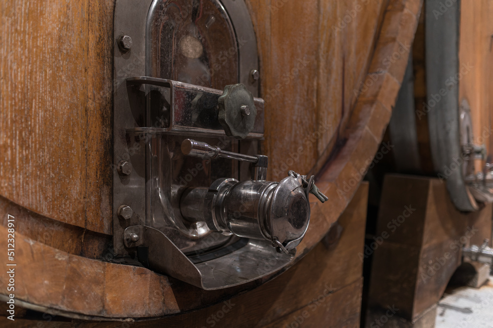 Stacked wooden barrels in a wine cellar, production and aging red wine in the traditional way Stacked wooden barrels in a wine cellar, production and aging red wine in the traditional way