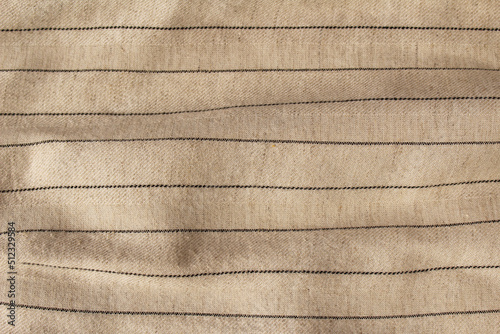 Beige crumpled fabric linen with stripe for creative background. Copy space. Natural textile for wallpaper or design