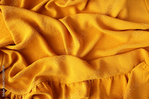 Orange ocher crumpled fabric for creative background. Copy space. Vivid textile for wallpaper or design