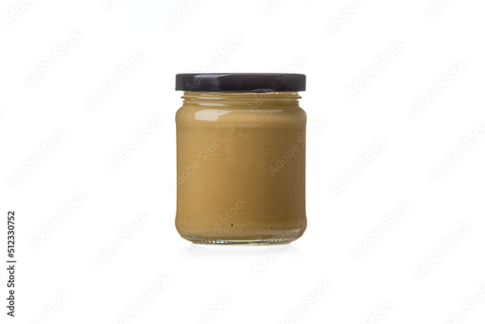 Closed glass jar with Dijon mustard on a white background. Closed glass jar with Dijon mustard on a white background.
