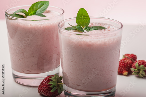 Fresh strawberry milkshake garnished with mint leaves.Cool summer drink. Selective focus.