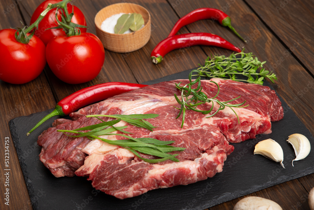 Raw beef steak on wooden table top. Healthy food concept. beef cut and spices for cooking bbq sauce Raw beef steak on wooden table top. Healthy food concept. beef cut and spices for cooking bbq sauce