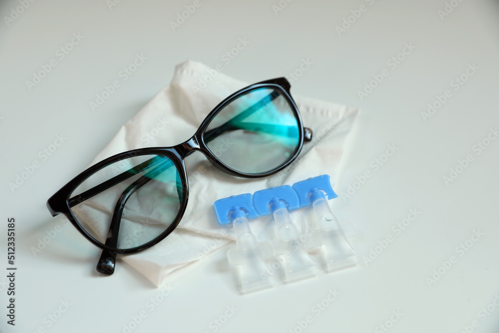 Single dose eye drops, glasses and fabric on white table Single dose eye drops, glasses and fabric on white table