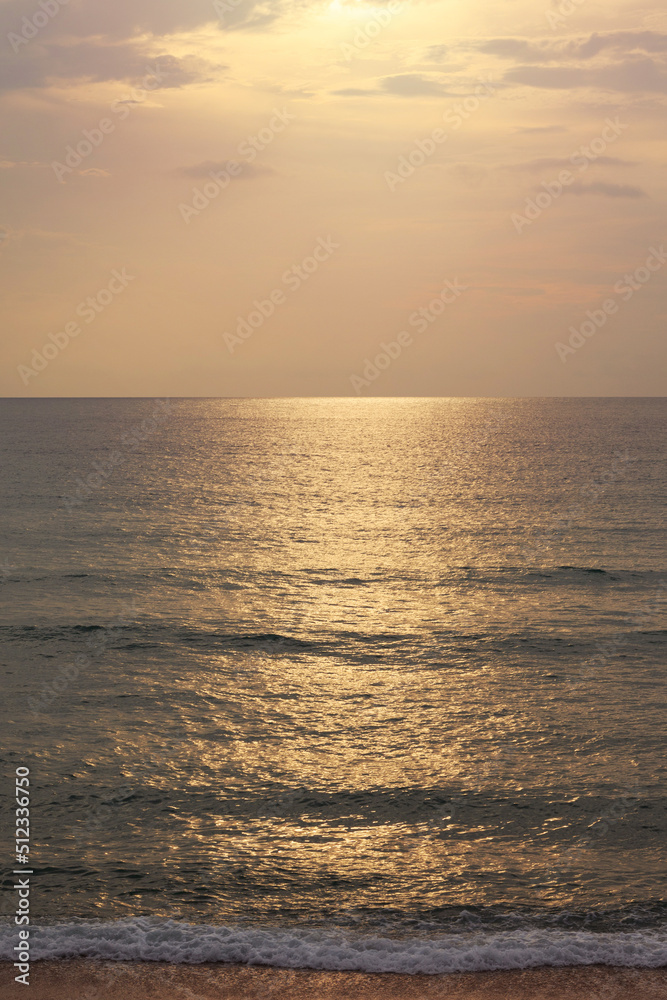 Sunset on the beach. Scenic seascape with clouds, waves and sun.