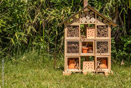 Insect house in the garden. Bug hotel at the park with plants in Switzerland. © Cherry