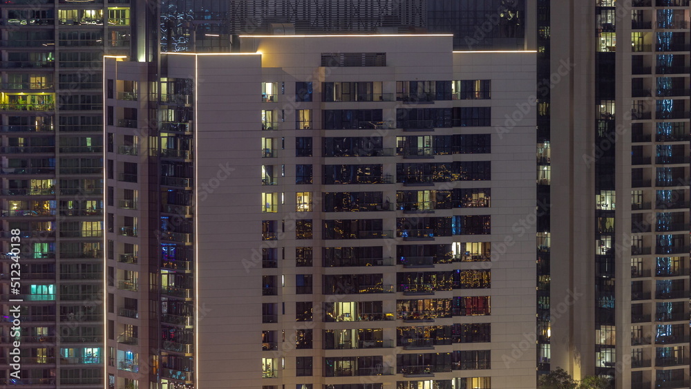 Windows illuminated at night in modern residential buildings timelapse.