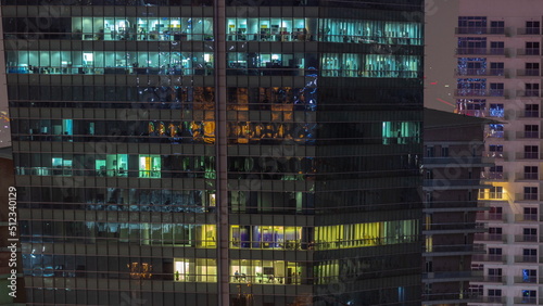 Windows illuminated at night in modern office buildings timelapse.
