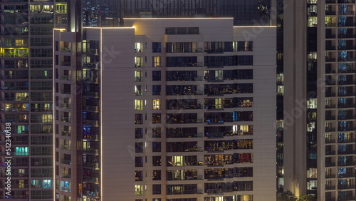 Windows illuminated at night in modern residential buildings timelapse.