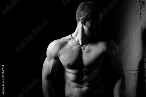 Muscular and sexy torso of young man having perfect abs, bicep and chest. Male hunk with athletic body. Fitness concept. © sergiophoto