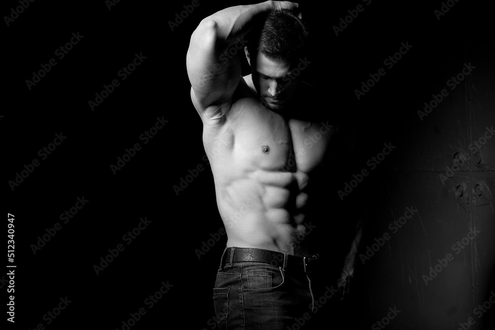 Muscular and sexy torso of young man having perfect abs, bicep and chest. Male hunk with athletic body. Fitness concept.