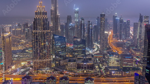 Aerial view of tallest towers in Dubai Downtown skyline and highway day to night timelapse.