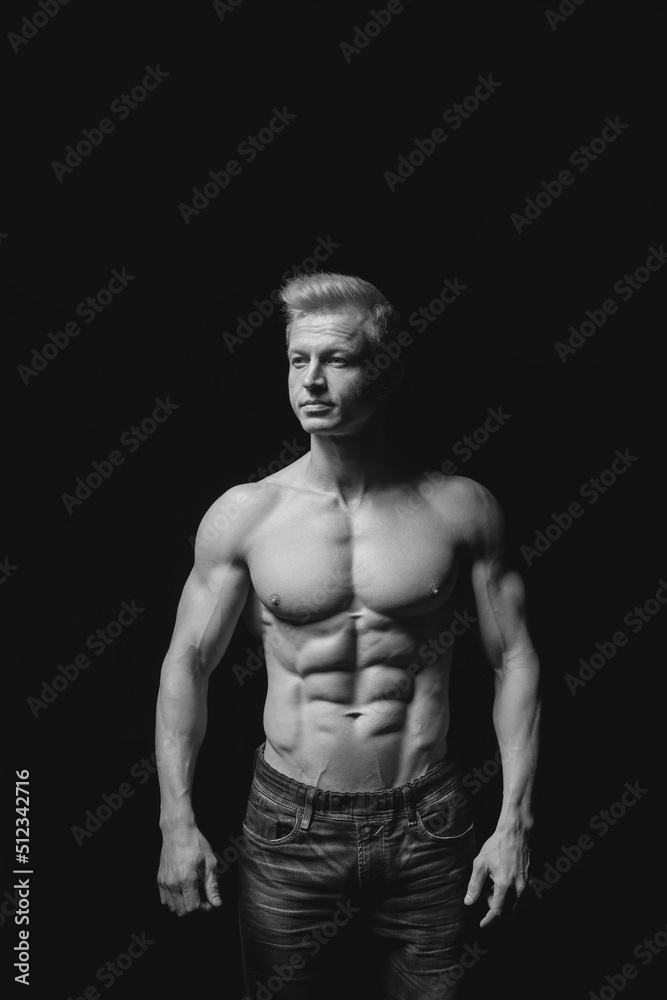 Fitness concept. Muscular and fit torso of young man having perfect abs, bicep and chest. Male hunk with athletic body on black background Fitness concept. Muscular and fit torso of young man having perfect abs, bicep and chest. Male hunk with athletic body on black background