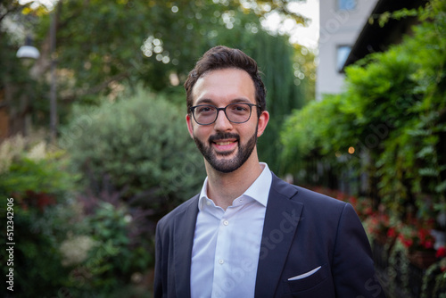 Portrait of a smiling caucasian businessman in elegant suit outdoors.