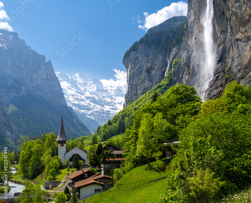 Amazing alpine landscape in Lauterbrunnen village with church and waterfall in Switzerland