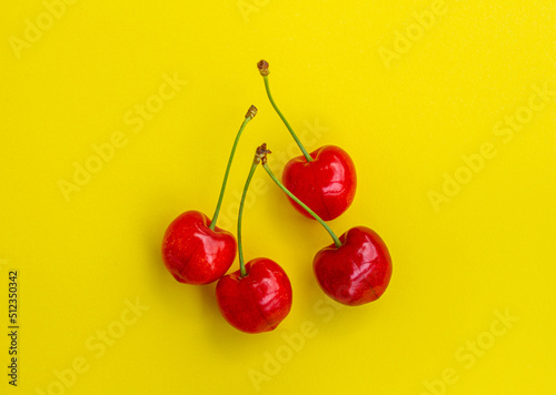Top view cherry fruits isolated on yellow background. Minimal cherry background photo.