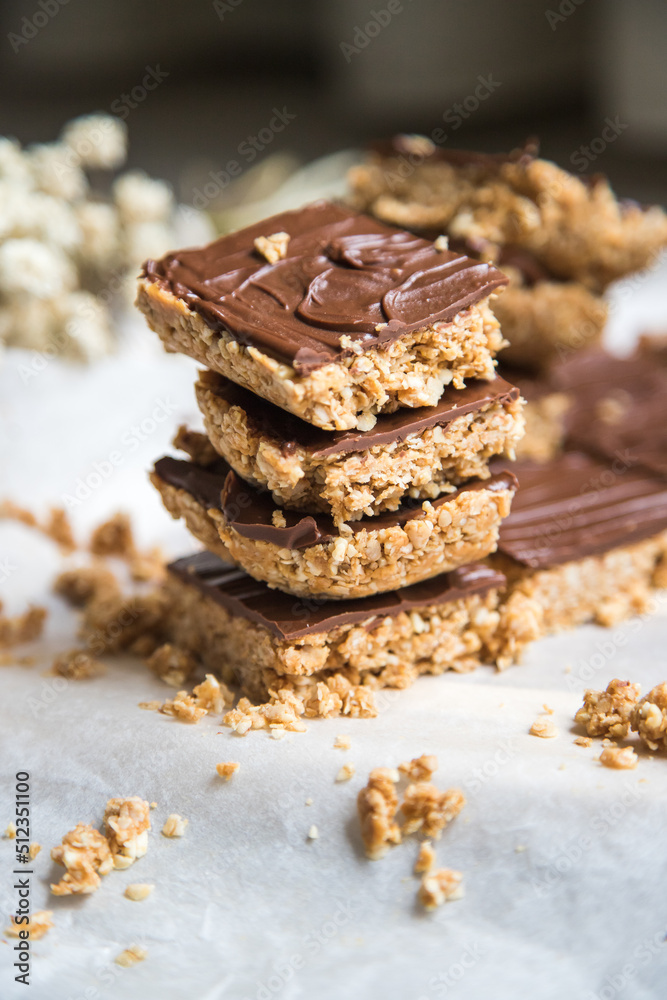 High energy oatmeal squares, made with oatmeal, peanut butter, honey, coconut oil, and cashews, topped with chocolate. Close view and shallow depth of field.