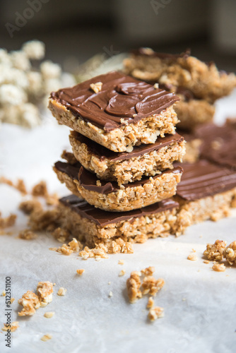 High energy oatmeal squares  made with oatmeal  peanut butter  honey  coconut oil  and cashews  topped with chocolate. Close view and shallow depth of field.