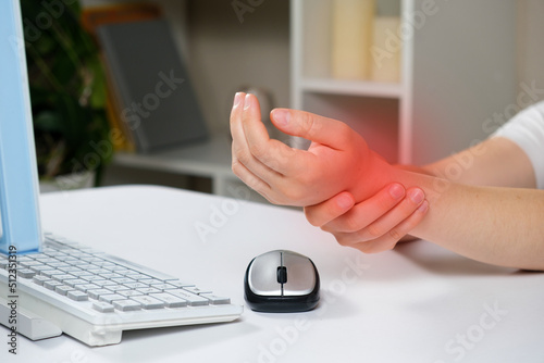 Hands of a person with carpal tunnel syndrome, a computer and a mouse photo