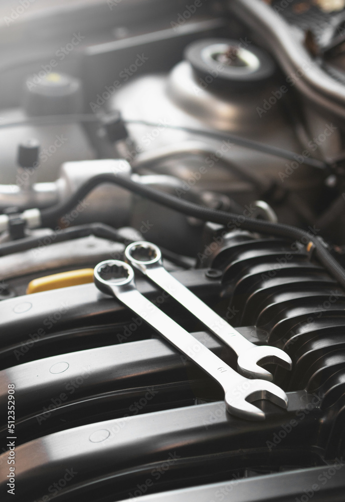 Wrenches lie on the engine of the car in the engine compartment.