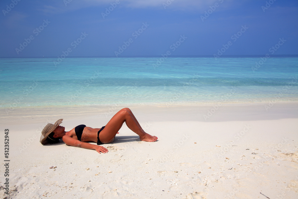 Girl lying on the beach at the seashore, Biyadhoo island, Maldives Girl lying on the beach at the seashore, Biyadhoo island, Maldives