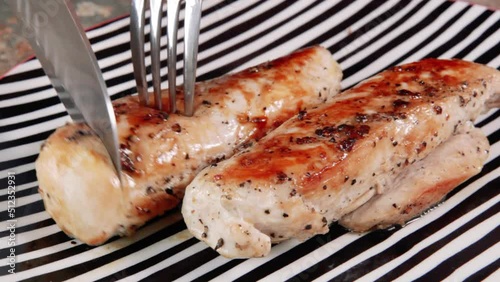Knife cutting chicken steak.