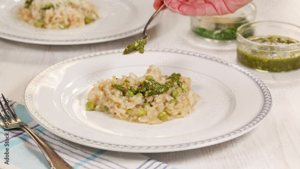Risotto with green peas and herbs pesto on a white plate. Risotto with green peas and herbs pesto on a white plate.
