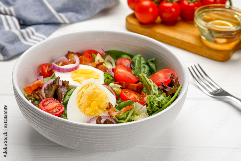 Delicious salad with boiled egg, bacon and vegetables on white wooden table, closeup Delicious salad with boiled egg, bacon and vegetables on white wooden table, closeup