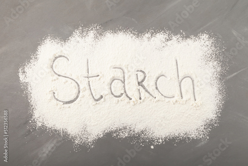Starch scattered on grey background. Inscription Starch, food ingredient for baking photo
