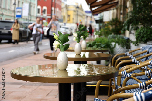 Photography Street cafe in summer city with empty wet tables outdoor on walking people background