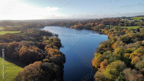 Aerial view looking down onto a lake surrounded by trees and countryside. 