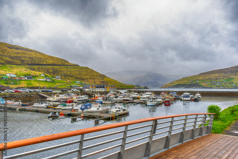 Boats parked in the bay, among the beautiful mountains. Clouds, fog. Faroe islands. Denmark. Europe.Transport. Water transport. Landscapes.