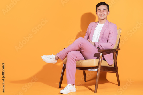 Image of young Asian man sitting on chair
