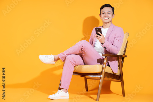 Image of young Asian man sitting on chair
