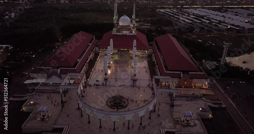 Circling drone shot of the great Mosque of Central Java (MAJT) in the night. The light is on. It have some pillars and some umbrela that is closed photo