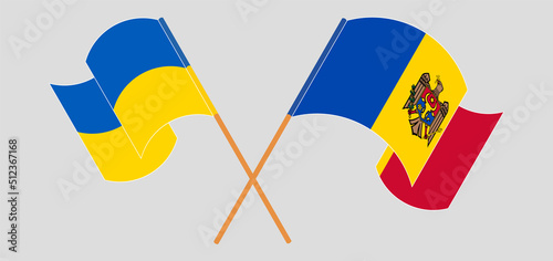 Crossed and waving flags of Ukraine and Moldova