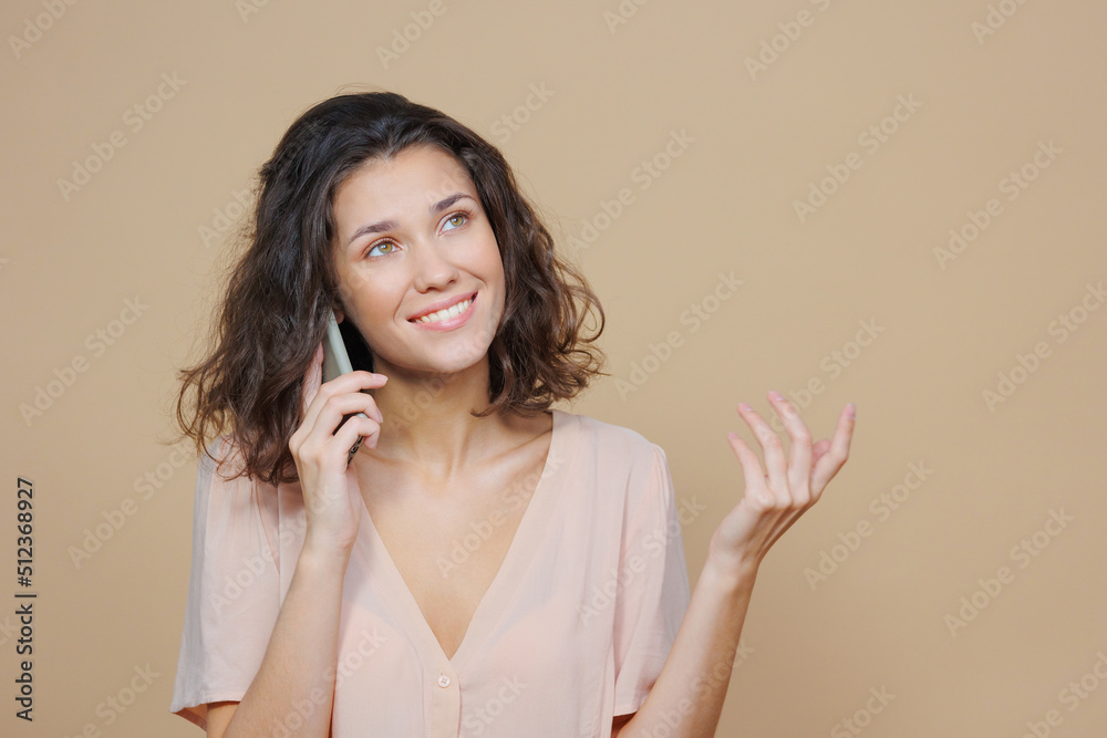 woman on a beige background smiles and makes a gesture with her hands. an advertising poster for a sale, a successful confident young woman with a phone in her hands. mock up, portrait of a woman with woman on a beige background smiles and makes a gesture with her hands. an advertising poster for a sale, a successful confident young woman with a phone in her hands. mock up, portrait of a woman with