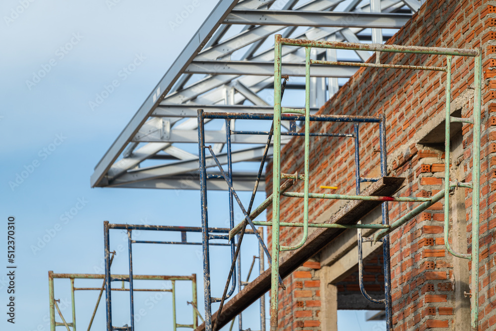 Iron scaffolding structure for new house building activity. Construction industrial working site photo. Selective focus.