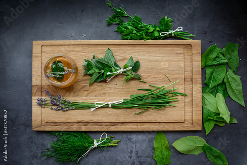 Various herbs picked from the garden, getting ready for drying, on wooden background