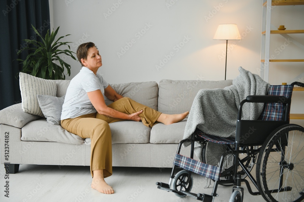 Brunette woman on couch near wheelchair Brunette woman on couch near wheelchair