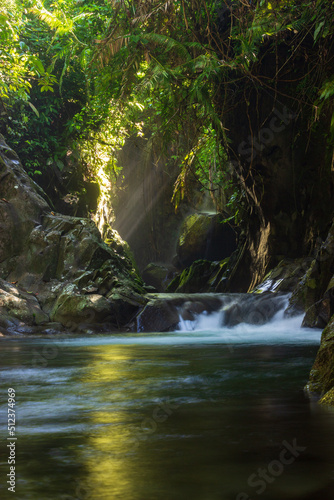 waterfall in indonesian tropical forest with morning sun