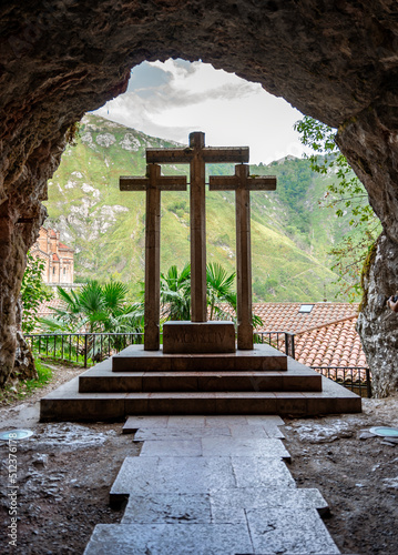 A statue of crosses outside of a church with mountains in the back Fototapet