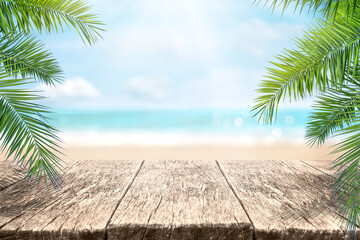 Empty wood table over blue sea, beach and palm leaves background in summer day. Background with copy space for product display