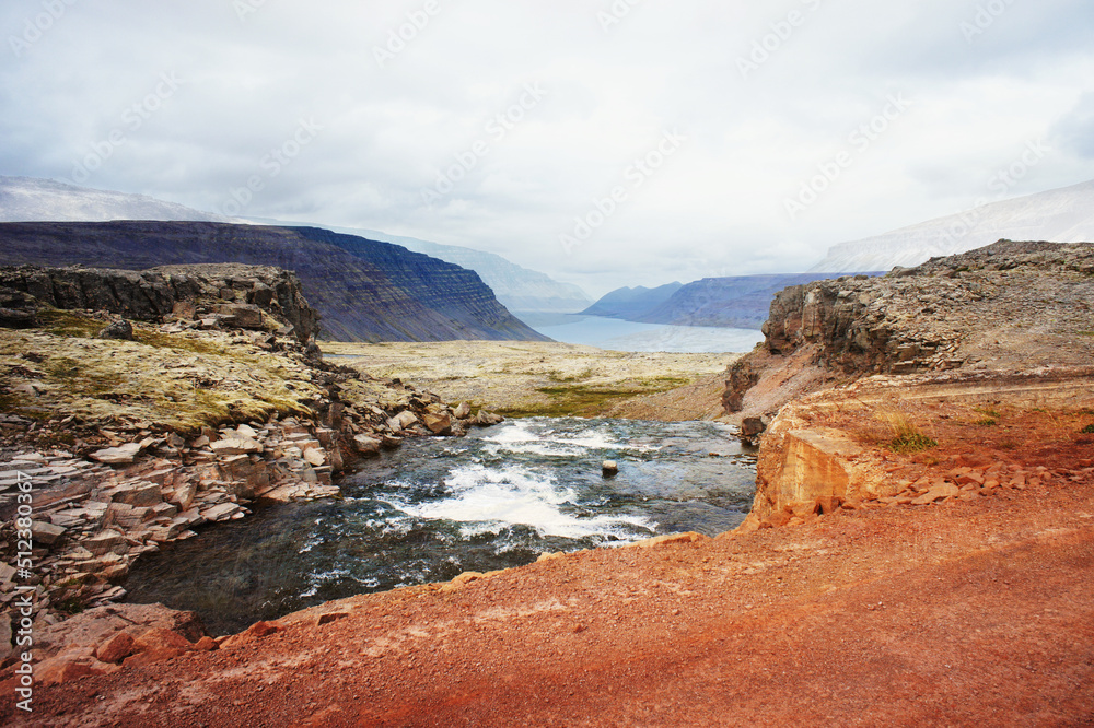 Scenic view of cliffs of Iceland against mountains and the North Atlantic Ocean and red ground beautiful landscape nature selective focus