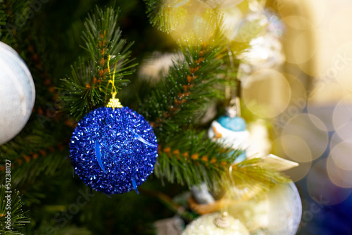 Christmas tree branch decorated with a blue sparkling ball close-up, festive card